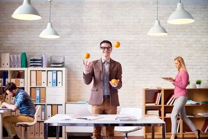 Man juggling oranges to demonstrate multitasking