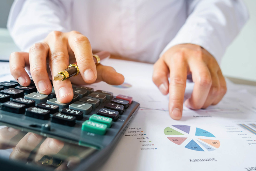 Man uses a calculator and looks at a pie chart and demonstrates that investing is a skill