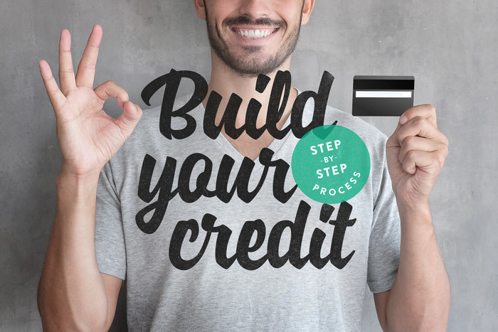 Man smiling holding a credit card