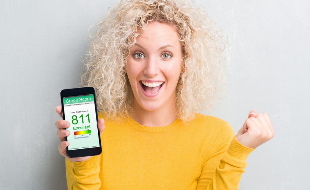 woman shows high credit score on her mobile phone