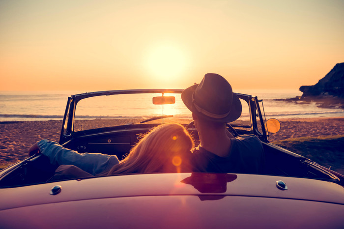 Couple at the beach discussing different types of car insurance