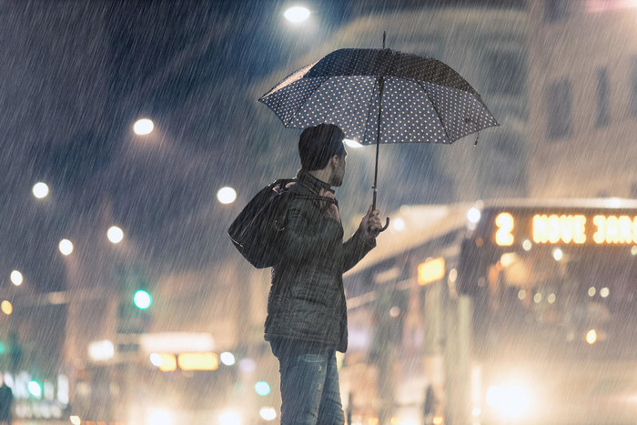 Man holding umbrella covered with income protection insurance