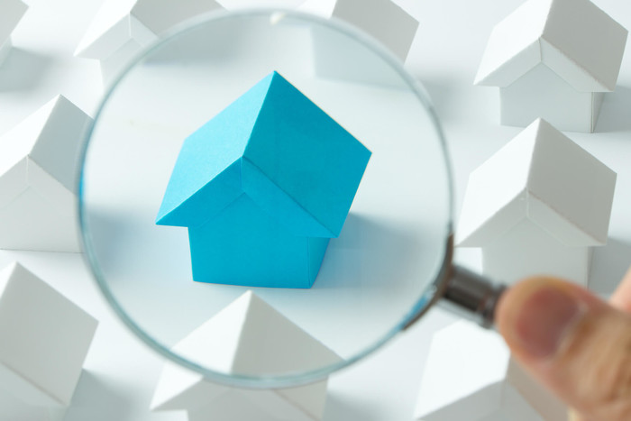 Real estate property under magnifying glass